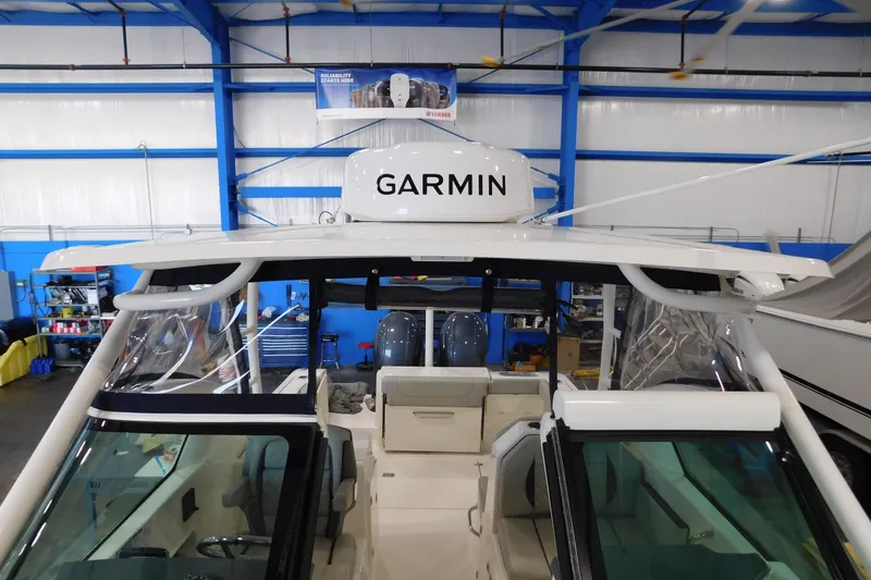 Slide: The Image of 2022 Pursuit DC 266 Dual Console boat with Garmin equipment in a blue indoor showroom. - 50