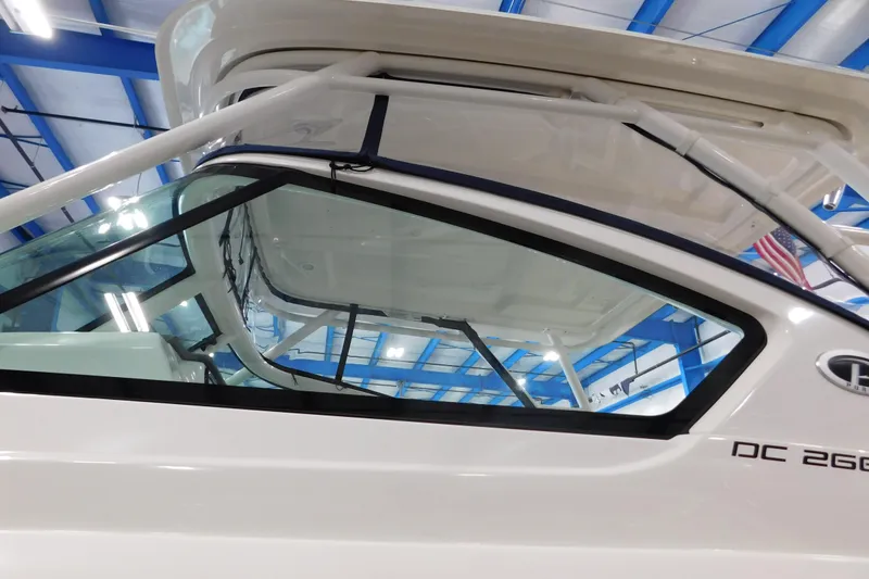 Slide: The Image of 2022 Pursuit DC 266 Dual Console boat in a showroom, showcasing sleek design and structure. - 6