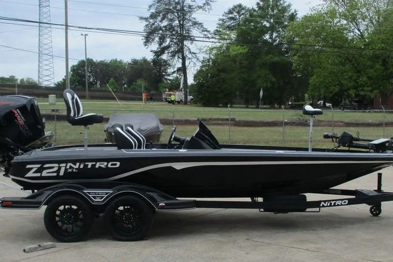 The Image of Black Tracker Pro Guide V-16 WT boat on trailer, parked outdoors, 2026 model. - 0