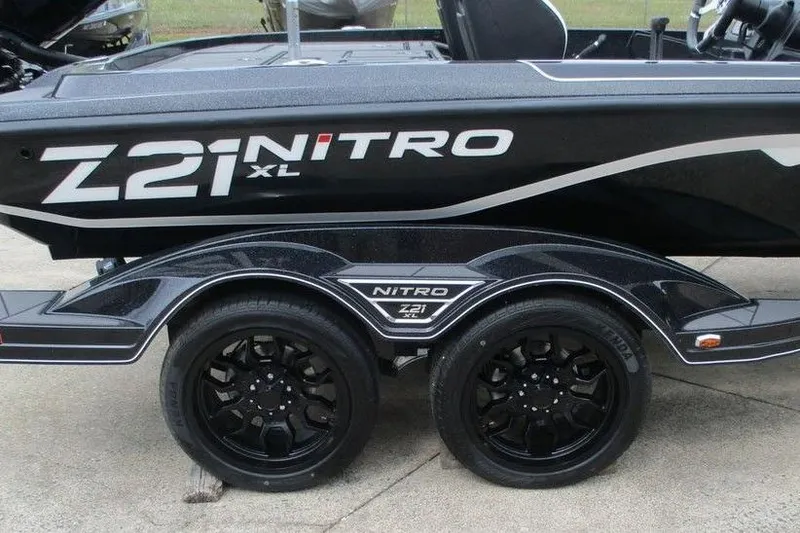 Slide: The Image of 2026 Tracker Pro Guide V-16 WT boat trailer with Nitro Z21 XL branding and black wheels. - 12