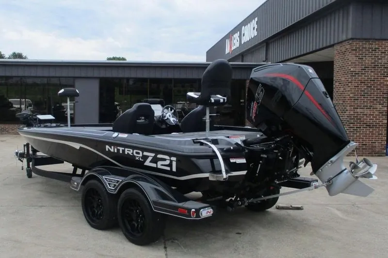 Slide: The Image of 2026 Tracker Pro Guide V-16 WT boat, parked outside a dealership, featuring sleek design and powerful engine. - 2