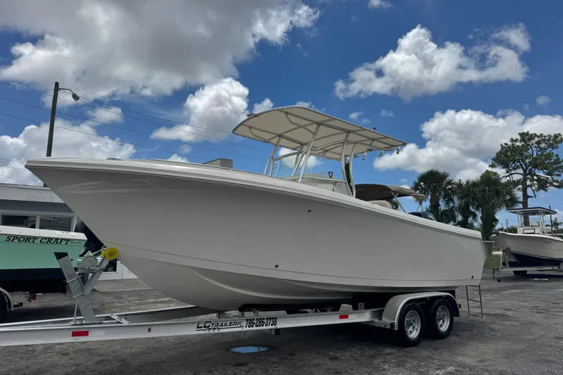 The Image of 2023 Sailfish 242 CC boat on trailer under a partly cloudy sky. - 0