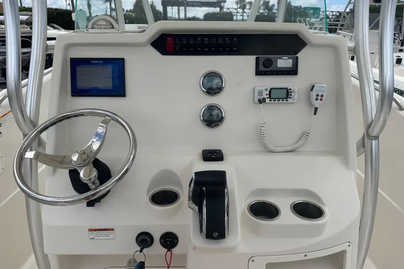 Slide: The Image of Helm of 2023 Sailfish 242 CC boat with steering wheel and navigation controls. - 10