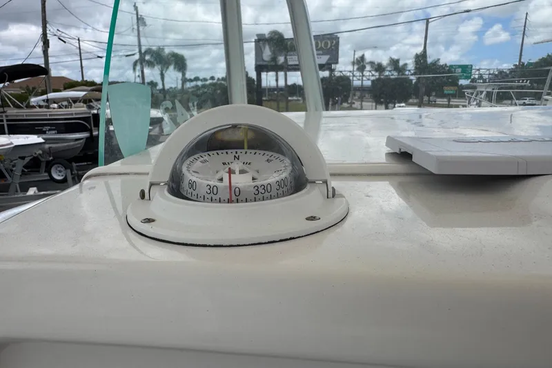 Slide: The Image of Compass on 2023 Sailfish 242 CC boat dashboard, with outdoor background. - 12