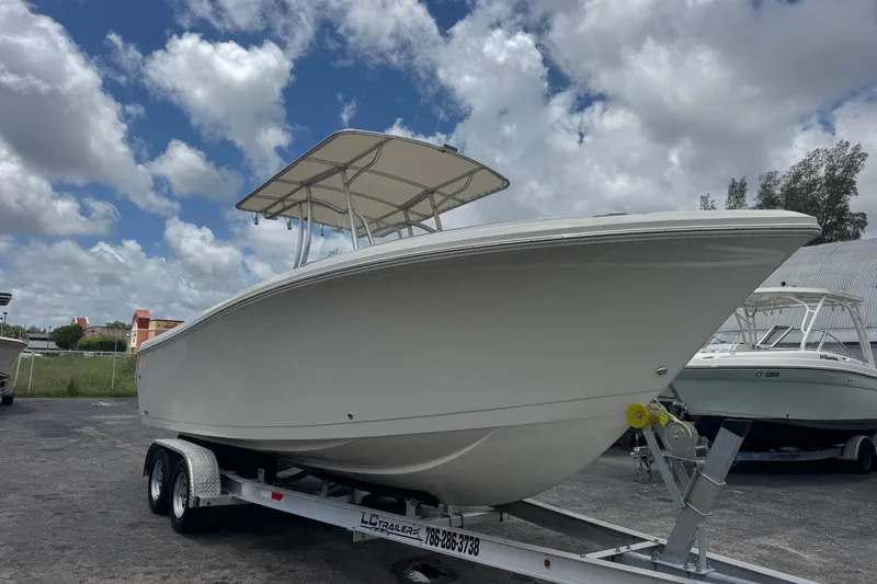 Slide: The Image of 2023 Sailfish 242 CC boat on trailer under cloudy sky. - 2