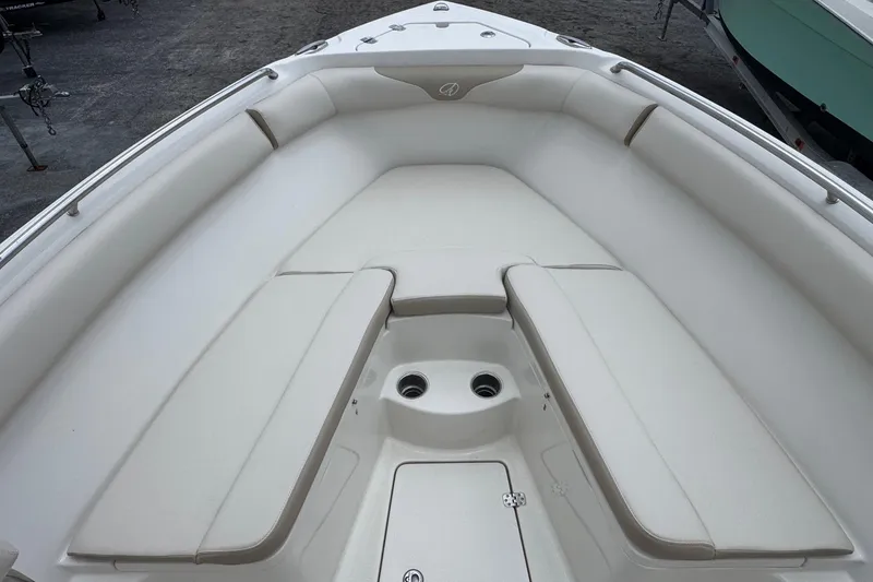 Slide: The Image of 2023 Sailfish 242 CC boat interior with white cushioned seating and storage compartment. - 20