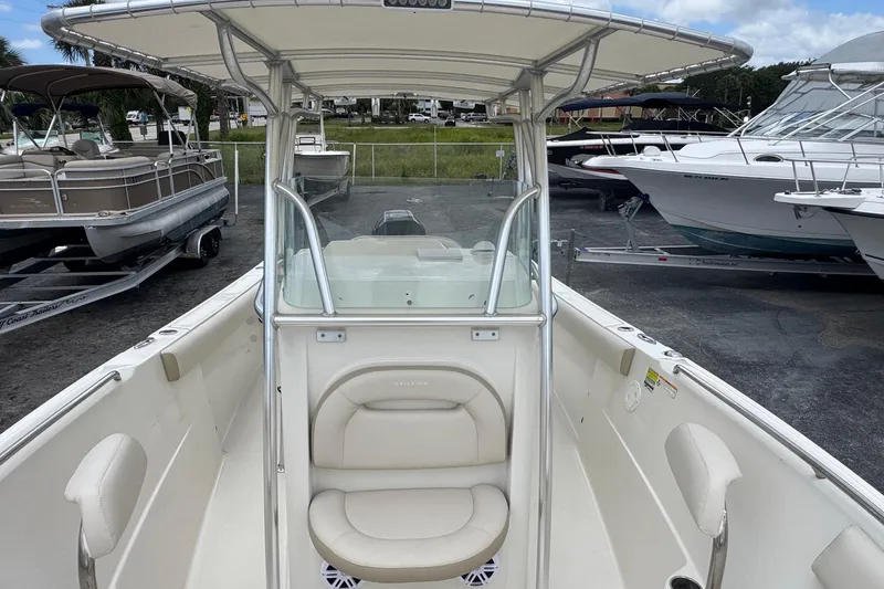 Slide: The Image of 2023 Sailfish 242 CC boat with center console and seating, docked at a marina. - 22