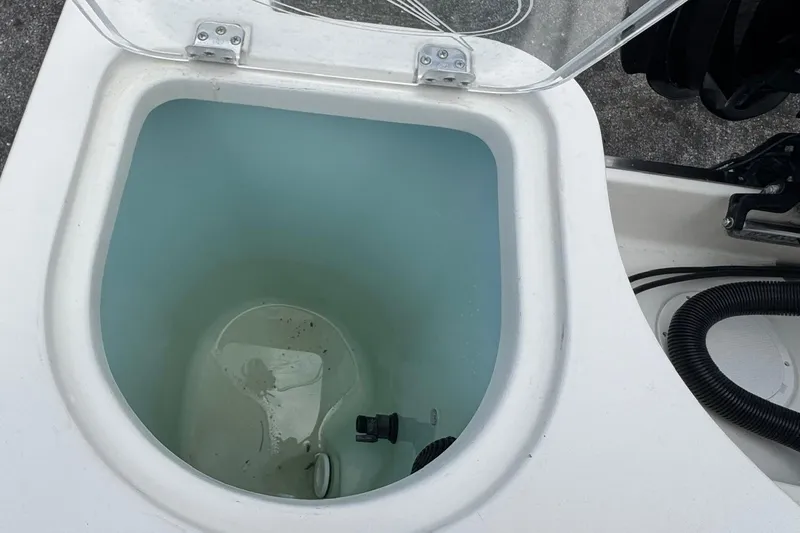 Slide: The Image of Livewell on 2023 Sailfish 242 CC boat, open lid, showing interior water. - 29