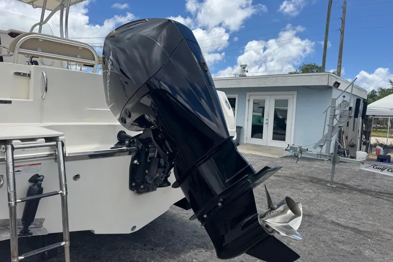 Slide: The Image of 2023 Sailfish 242 CC boat with powerful outboard motor, docked under a clear blue sky. - 41