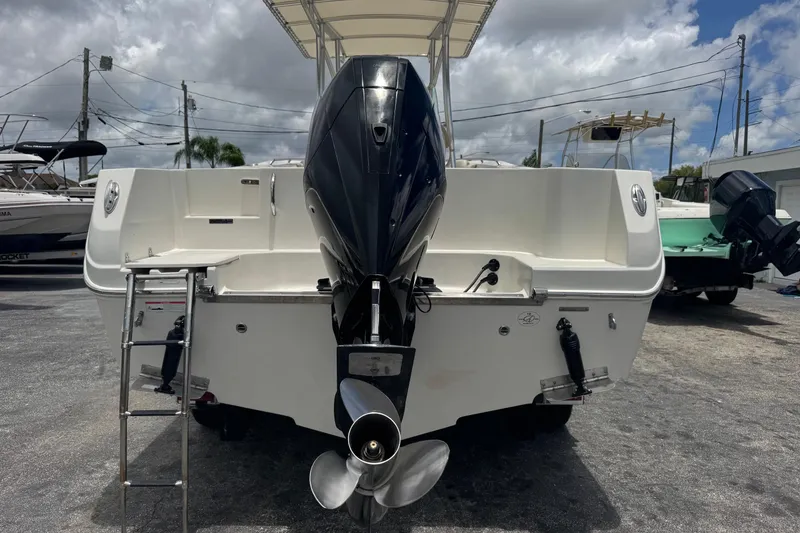 Slide: The Image of 2023 Sailfish 242 CC boat rear view with outboard motor and ladder. - 42