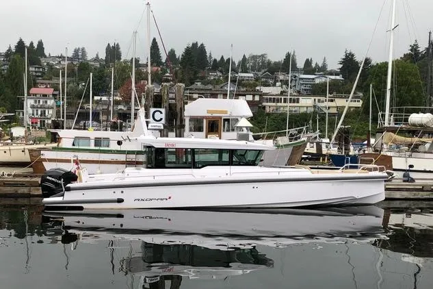 Slide: The Image of 2020 Axopar 37 XC Cross Cabin boat docked in a marina, surrounded by other vessels. - 4