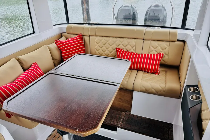 Slide: The Image of Luxurious interior of 2020 Axopar 37 XC Cross Cabin with beige seating and red striped pillows. - 27