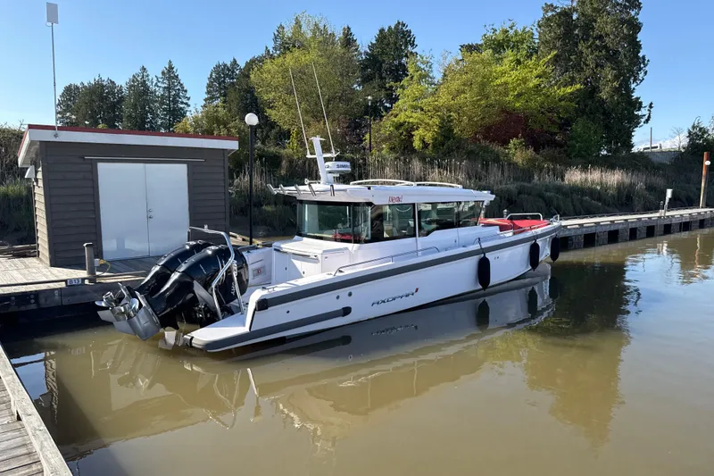 Slide: The Image of 2020 Axopar 37 XC Cross Cabin boat docked by a wooden pier. - 2