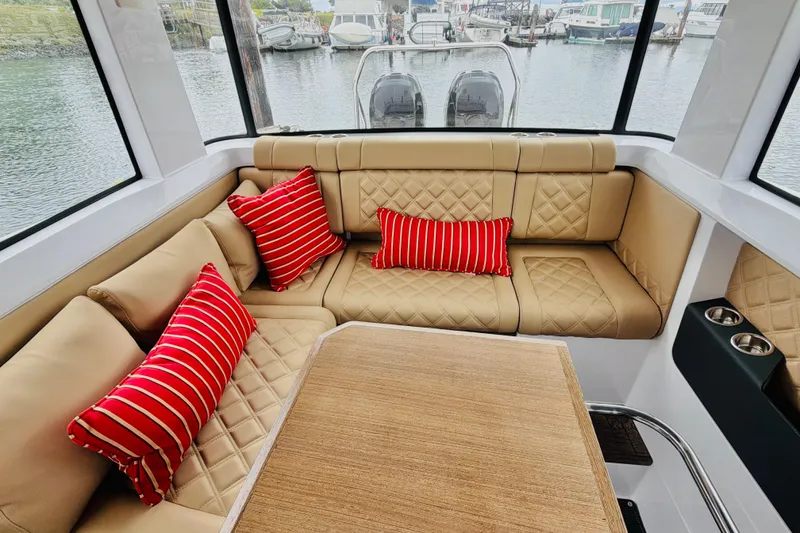 Slide: The Image of Luxurious interior of 2020 Axopar 37 XC Cross Cabin with beige seating and red striped pillows. - 24
