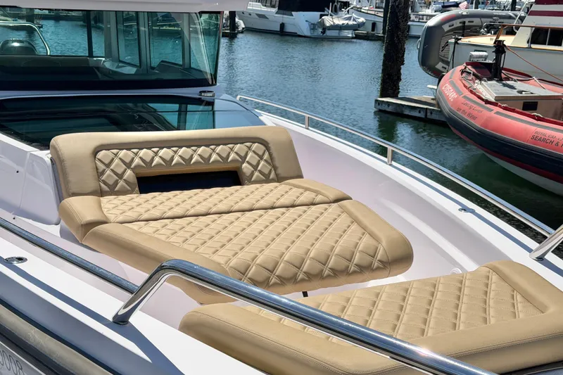 Slide: The Image of 2020 Axopar 37 XC Cross Cabin with luxurious tan seating at a marina. - 19