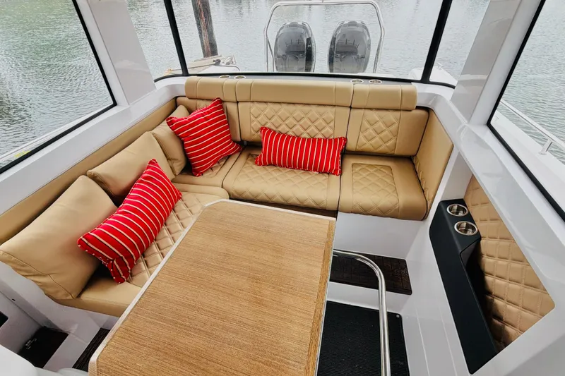 Slide: The Image of Luxurious interior of 2020 Axopar 37 XC Cross Cabin with beige seating and red striped pillows. - 25