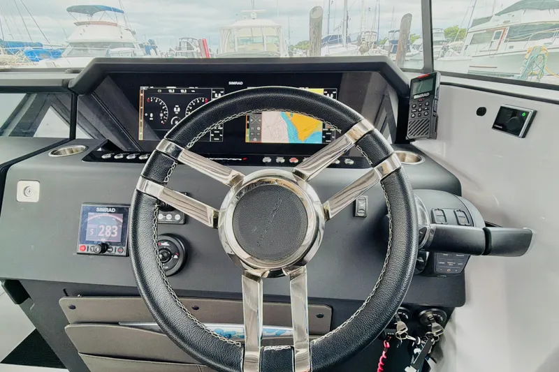 Slide: The Image of Steering wheel and dashboard of 2020 Axopar 37 XC Cross Cabin boat, featuring navigation displays. - 30