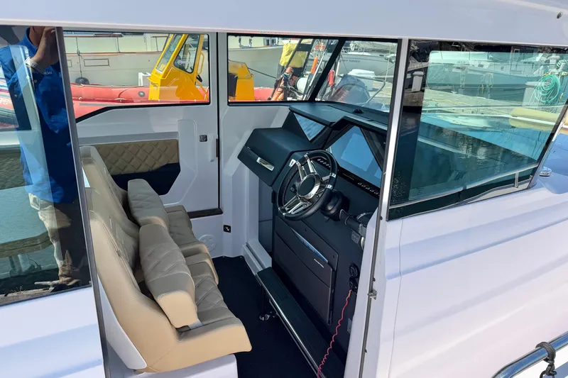 Slide: The Image of 2020 Axopar 37 XC Cross Cabin interior with steering wheel and seating. - 23