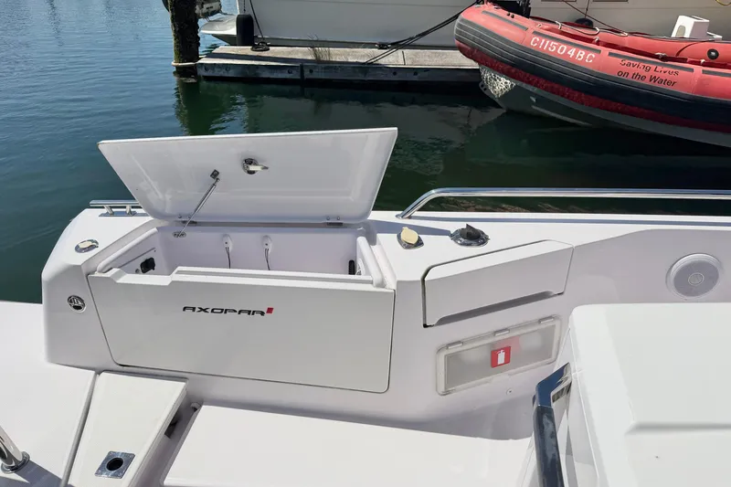 Slide: The Image of 2020 Axopar 37 XC Cross Cabin boat with open storage compartment at dock. - 12