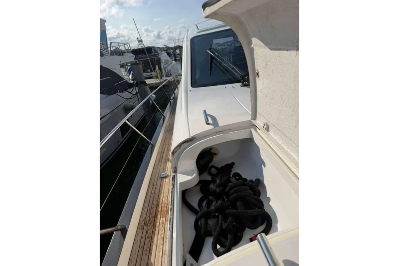Slide: The Image of 2005 Viking Princess V70 Express yacht deck with open storage compartment and coiled rope. - 17