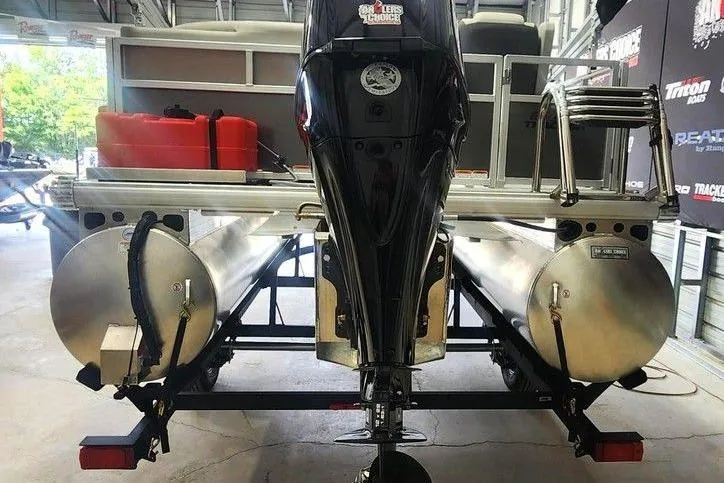Slide: The Image of 2026 Tracker Bass Tracker Classic XL boat with dual pontoons and outboard motor in a garage. - 5