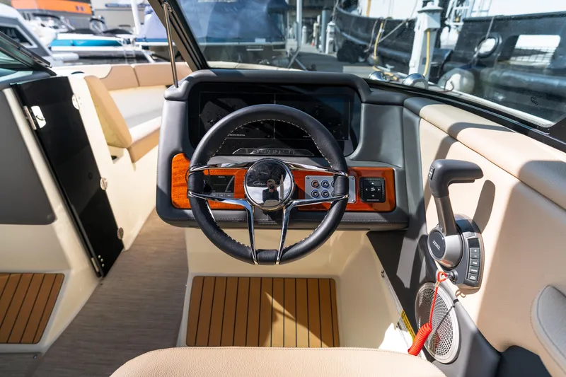 Slide: The Image of 2025 Chris-Craft Sportster 25 boat interior with steering wheel and control panel. - 11