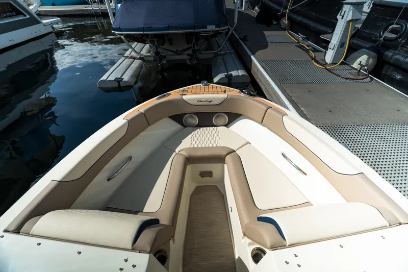 Slide: The Image of 2025 Chris-Craft Sportster 25 boat interior with beige seating at a marina dock. - 13