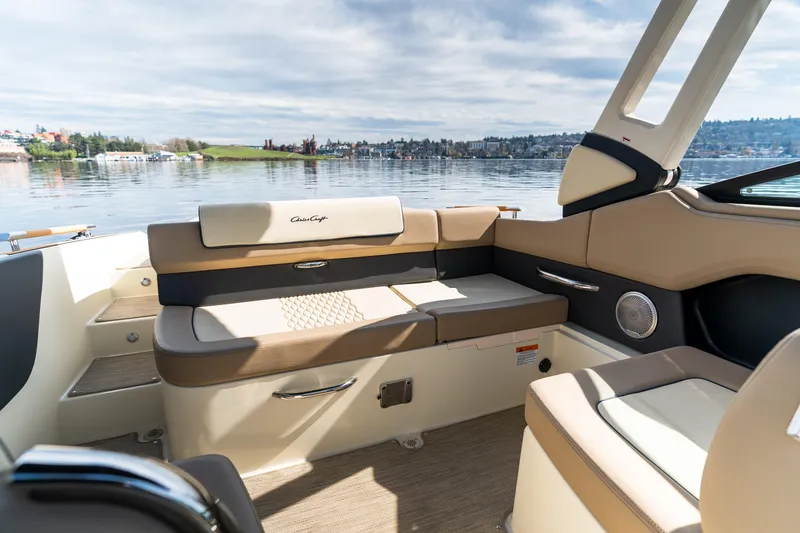 Slide: The Image of 2025 Chris-Craft Sportster 25 interior with beige seating, overlooking a serene lake. - 8