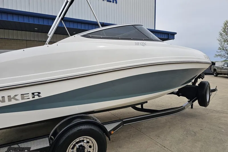 Slide: The Image of 2020 Rinker 19QX BR boat on trailer, parked outside a building. - 10