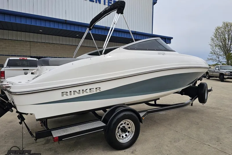 Slide: The Image of 2020 Rinker 19QX BR boat on trailer, parked outside a building. - 11