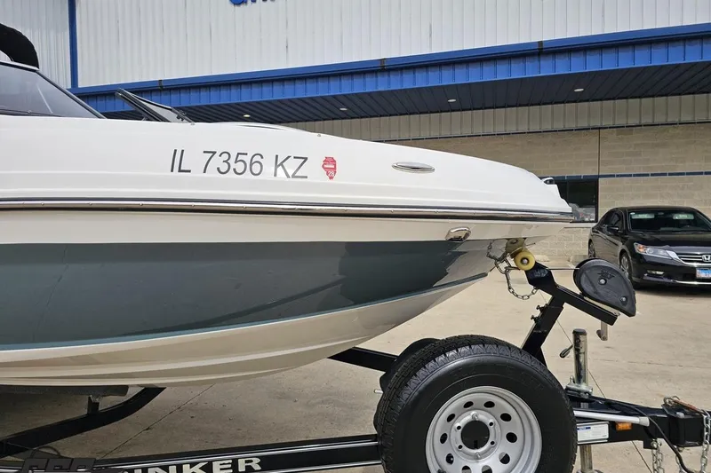 Slide: The Image of 2020 Rinker 19QX BR boat on trailer, parked outside a building. - 18