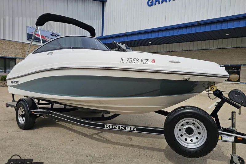 Slide: The Image of 2020 Rinker 19QX BR boat on trailer, parked outside a building. - 19