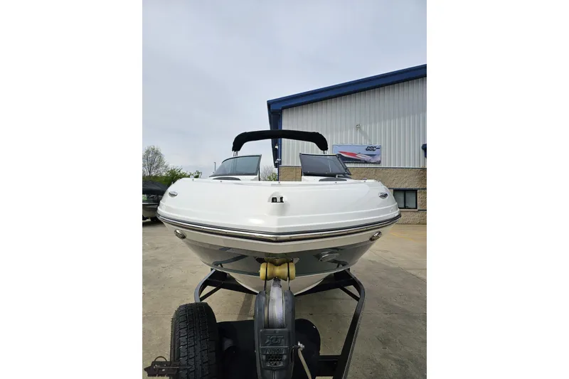 Slide: The Image of 2020 Rinker 19QX BR boat on trailer, parked outside a building. - 22