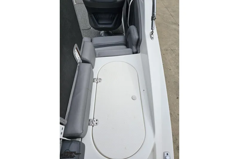 Slide: The Image of 2020 Rinker 19QX BR boat interior with gray seating and storage compartment. - 50