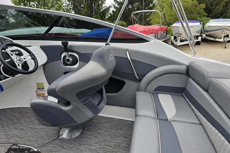 Slide: The Image of Interior of a 2020 Rinker 19QX BR boat with gray seating and steering wheel. - 55