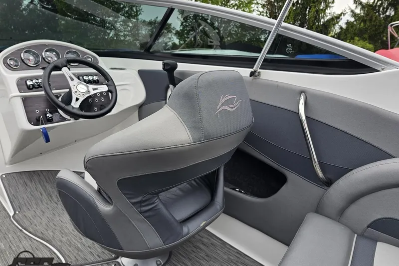 Slide: The Image of Interior of a 2020 Rinker 19QX BR boat, featuring steering wheel and seating. - 57