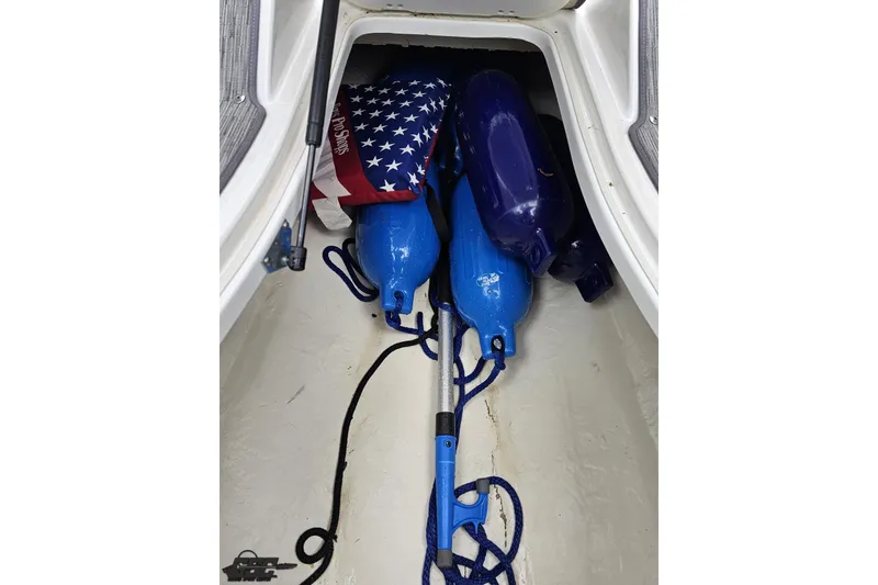 Slide: The Image of Storage compartment of 2020 Rinker 19QX BR boat with fenders and American flag. - 63