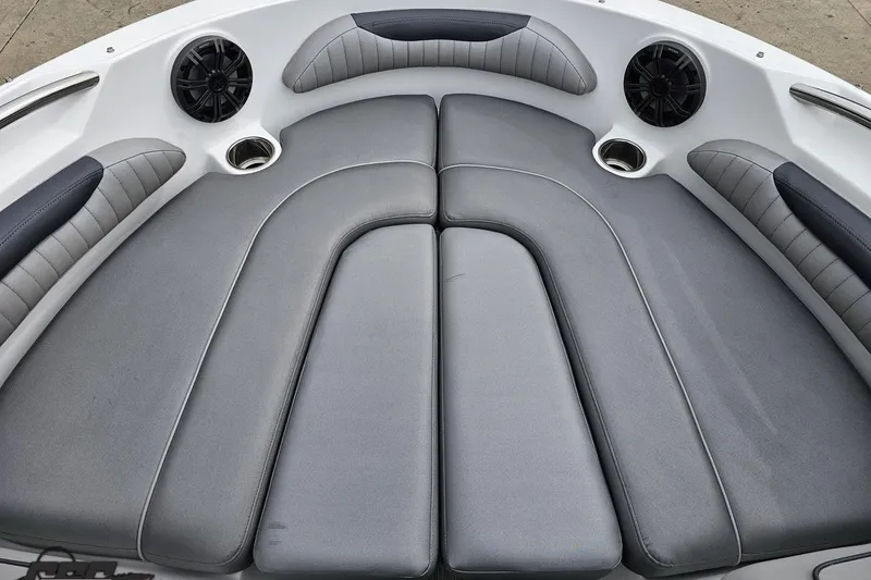 Slide: The Image of 2020 Rinker 19QX BR boat interior with gray cushioned seating and built-in speakers. - 72