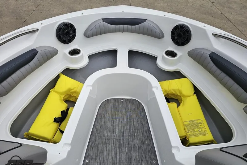 Slide: The Image of 2020 Rinker 19QX BR boat interior with gray seating and yellow life jackets. - 78
