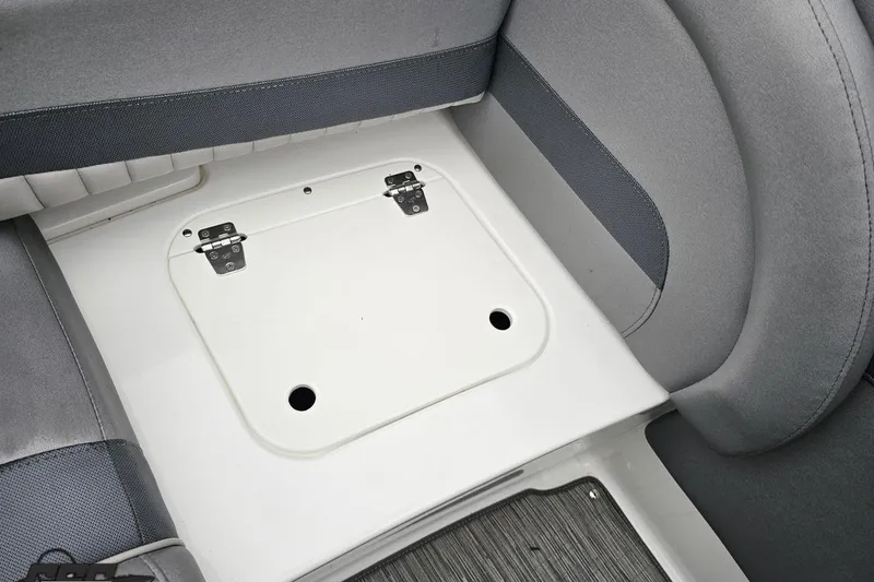 Slide: The Image of 2020 Rinker 19QX BR boat interior storage compartment with gray seating. - 86