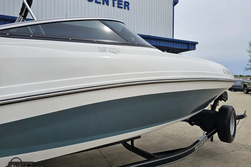 Slide: The Image of 2020 Rinker 19QX BR boat on trailer, parked outside a building. - 9