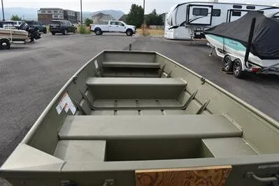 Slide: The Image of 2025 Lowe L1240 Jon boat in a parking lot, surrounded by vehicles and trailers. - 3