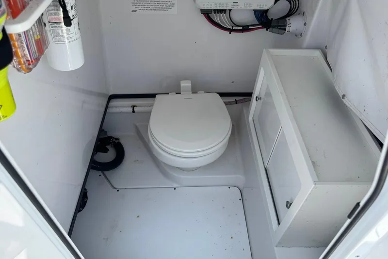Slide: The Image of Interior of a 2021 Sportsman Open 282 Center Console boat with a compact marine toilet. - 18