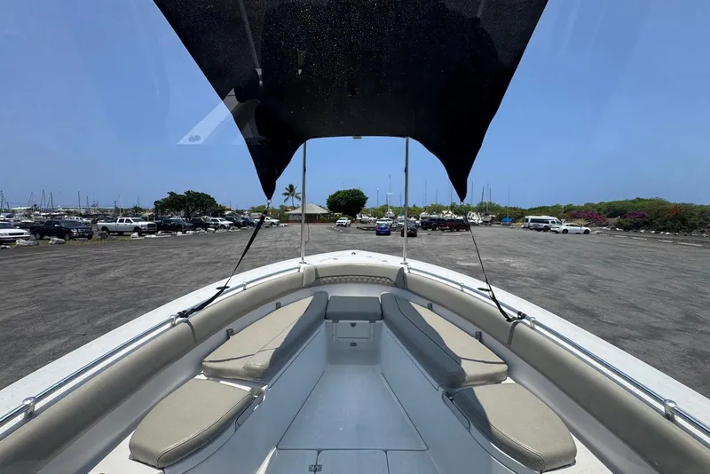 Slide: The Image of 2021 Sportsman Open 282 Center Console boat with seating and canopy in a marina parking area. - 9