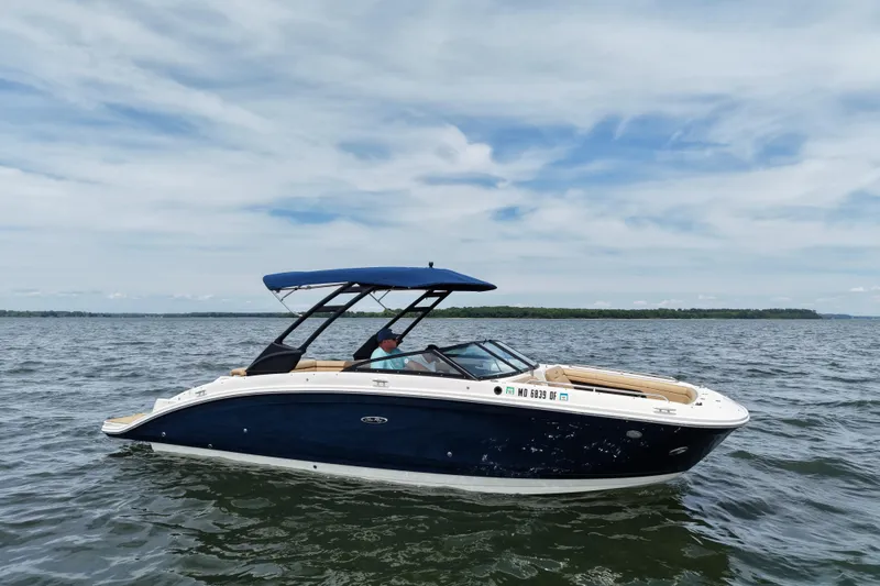The Image of 2021 Sea Ray SDX 270 boat cruising on a calm lake under a clear sky. - 0
