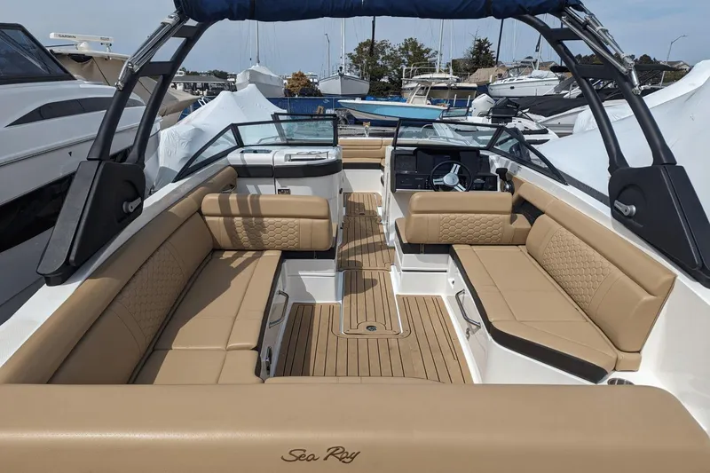 Slide: The Image of 2021 Sea Ray SDX 270 boat interior with tan seating and modern dashboard. - 12