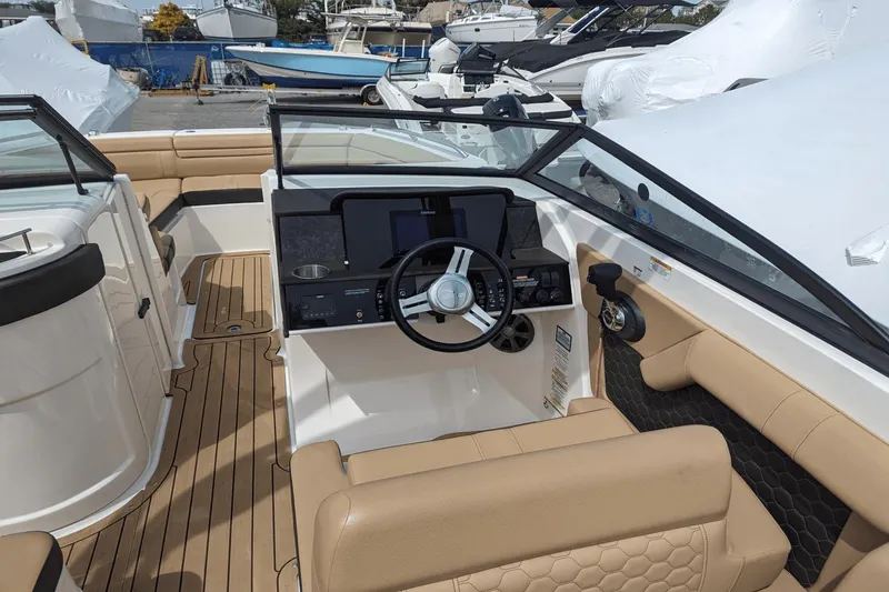 Slide: The Image of 2021 Sea Ray SDX 270 boat interior with beige seating and modern dashboard. - 13