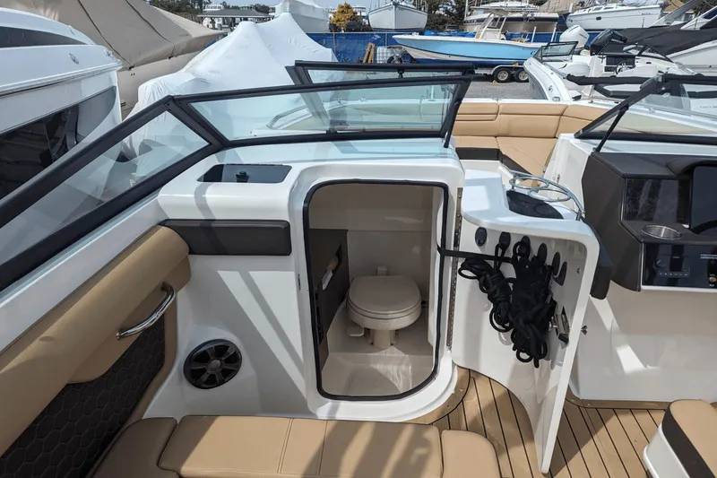 Slide: The Image of 2021 Sea Ray SDX 270 boat interior with open door revealing compact toilet. - 15