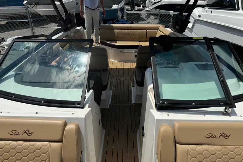 Slide: The Image of 2021 Sea Ray SDX 270 boat interior with tan seating and glass windshields. - 17