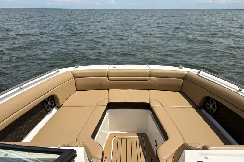 Slide: The Image of 2021 Sea Ray SDX 270 boat with tan seating and canopy on open water. - 2